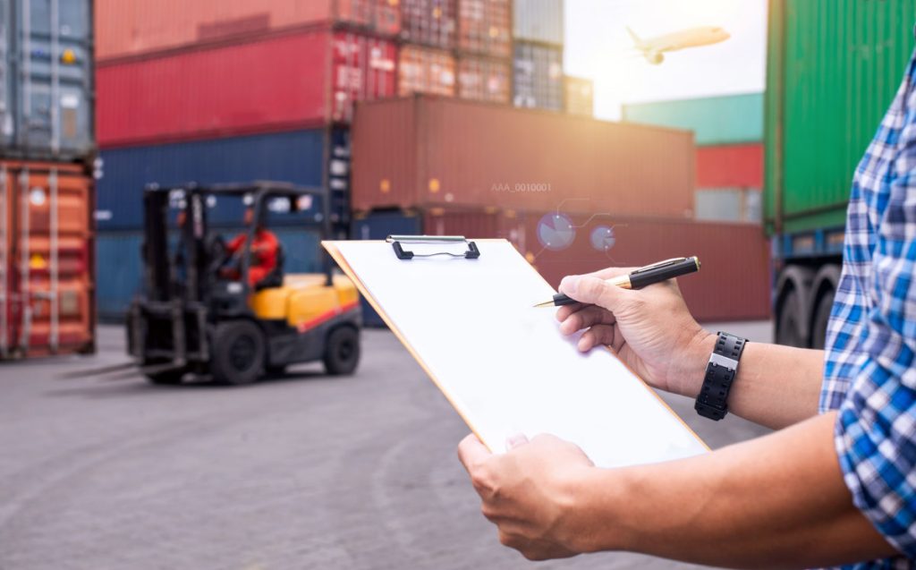 Shipping containers with forklift worker with a checklist