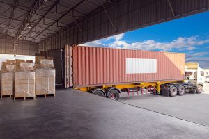 Truck with shipping container parked at warehouse unloading