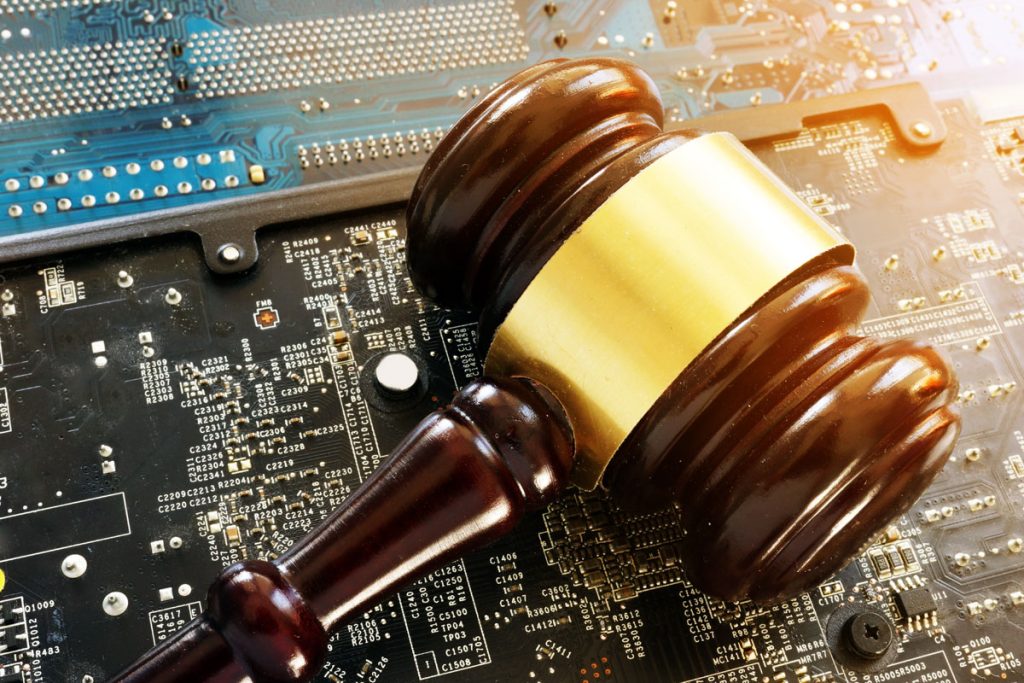 electronics-manufacturing-law-gavel-1a electronics manufacturing motherboard with law gavel over the processor chip