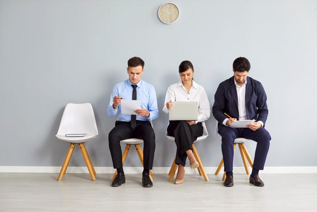 people sitting on stools in a room preparing for an interview